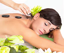 Bild einer jungen Frau bei einer Hot Stone- Massage.